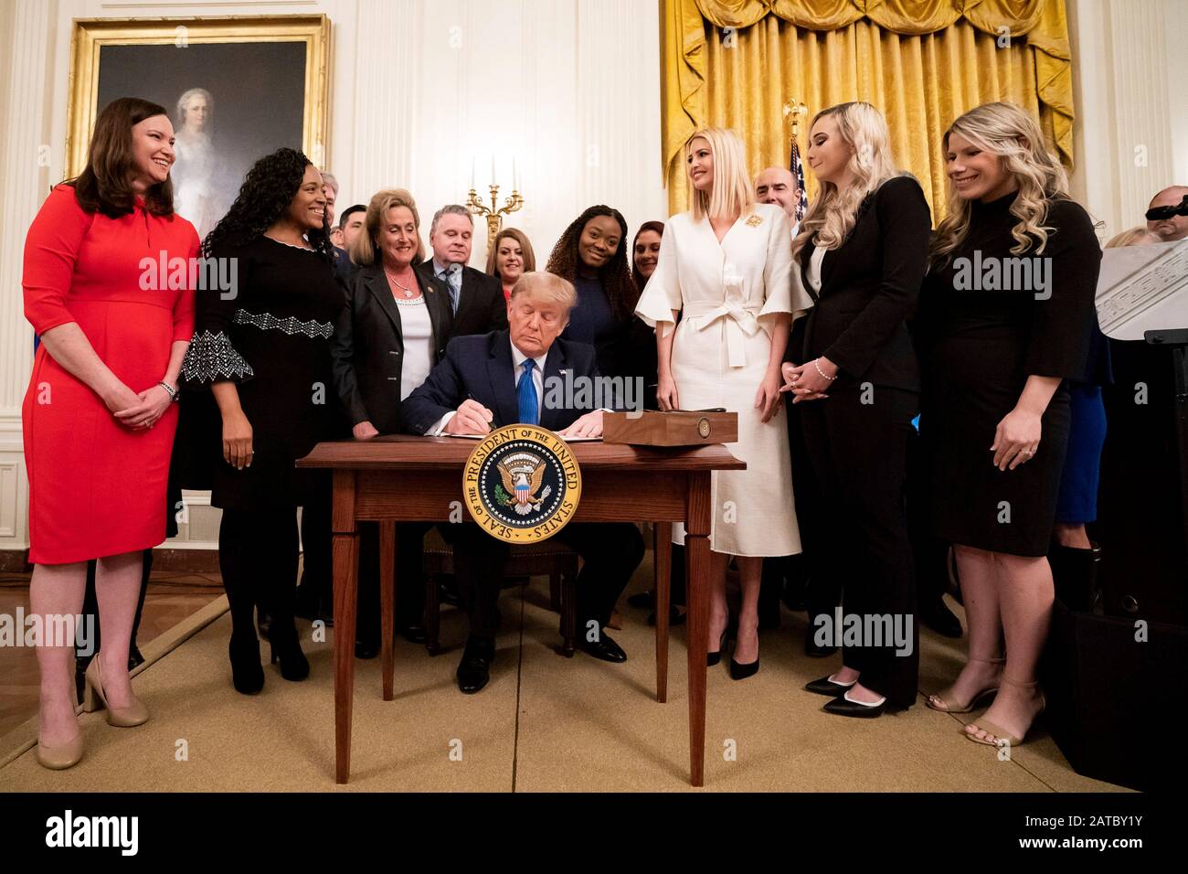 Washington, United States Of America. 31st Jan, 2020. Washington, United States of America. 31 January, 2020. U.S President Donald Trump, surrounded by survivors, officials and his daughter Ivanka Trump, right, signs an executive order to help combat human trafficking during a ceremony in the East Room of the White House January 31, 2020 in Washington, DC. The event took place following the White House Summit on Human Trafficking in honor of the 20th Anniversary of the Trafficking Victims Protection Act. Credit: Tia Dufour/White House Photo/Alamy Live News Stock Photo