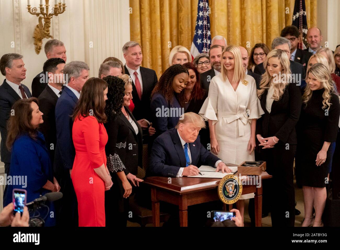 Washington, United States Of America. 31st Jan, 2020. Washington, United States of America. 31 January, 2020. U.S President Donald Trump, surrounded by survivors, officials and his daughter Ivanka Trump, right, signs an executive order to help combat human trafficking during a ceremony in the East Room of the White House January 31, 2020 in Washington, DC. The event took place following the White House Summit on Human Trafficking in honor of the 20th Anniversary of the Trafficking Victims Protection Act. Credit: Andrea Hanks/White House Photo/Alamy Live News Stock Photo