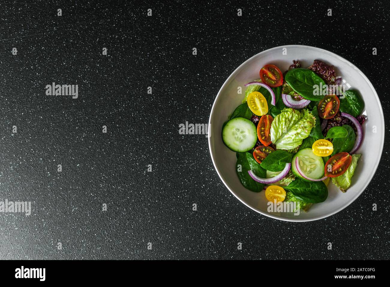 Top view of greens vegetable salad bowl with lettuce, spinach, and