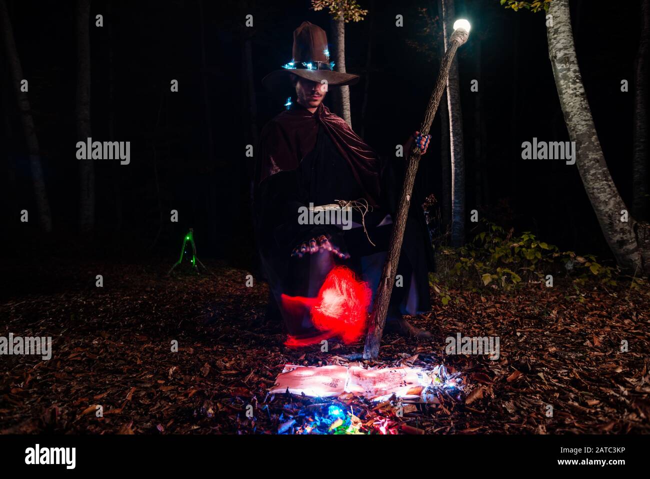 Wizard (mage) casting a spell with his magical staff while standing in ...