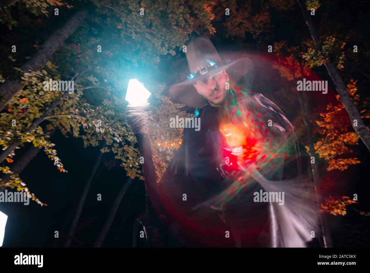 Wizard (mage) casting a spell with his magical staff while standing in ...