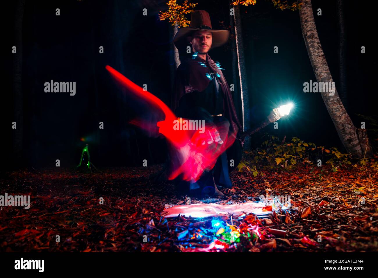 Wizard (mage) casting a spell with his magical staff while standing in ...