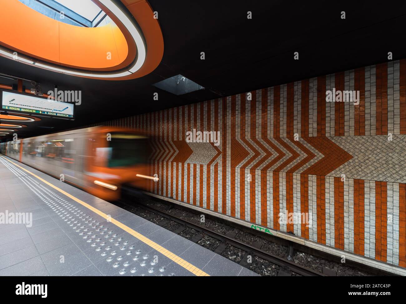 Laeken, Brussels Capital Region / Belgium - 09 25 2019: Metro train entering with high speed and blurred out lines in orange Stock Photo