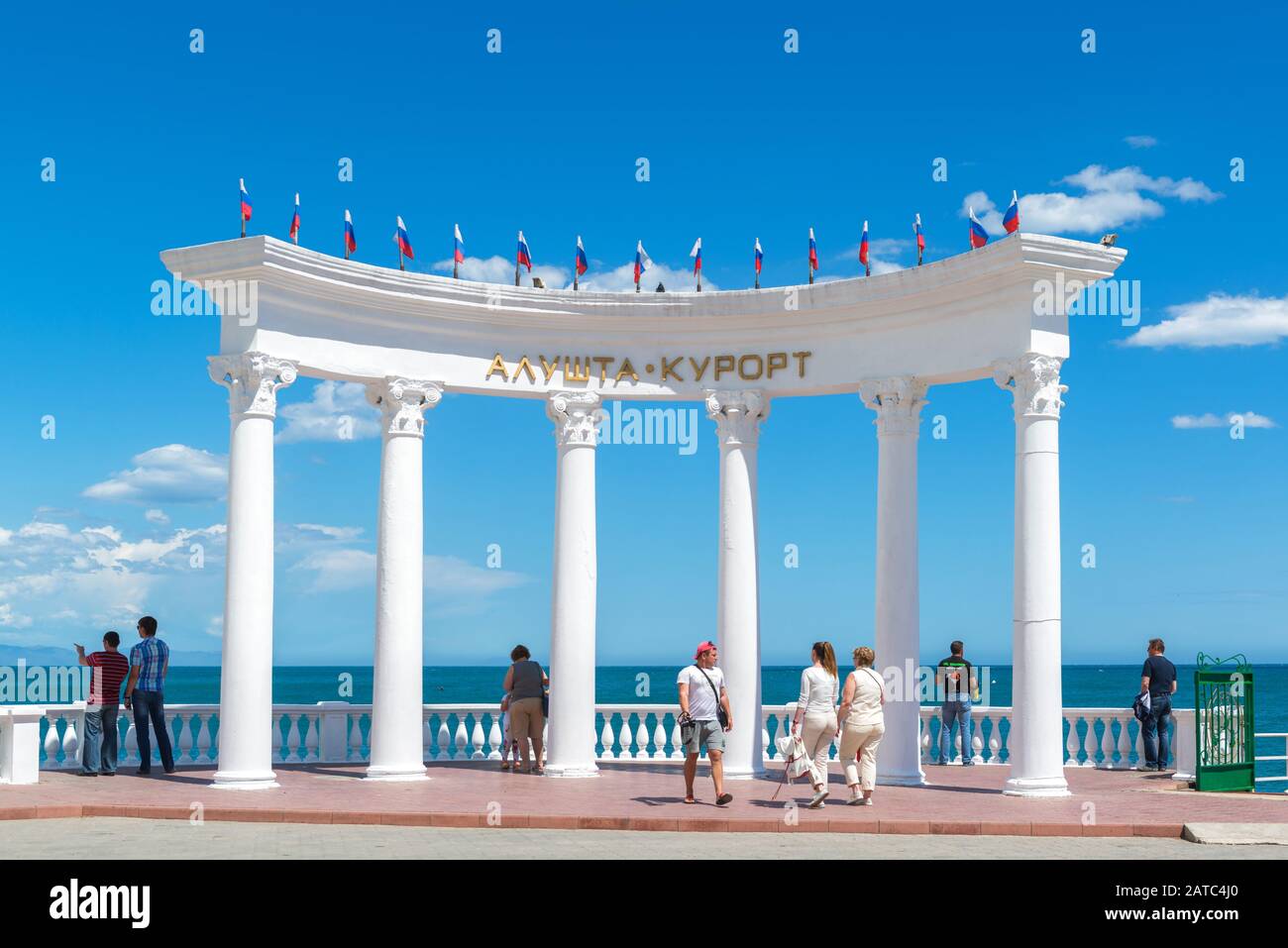 ALUSHTA, CRIMEA - MAY 15, 2016: People visit the rotunda 'Alushta resort' on the beach in Crimea, Russia. Scenic view of the Black Sea waterfront of C Stock Photo