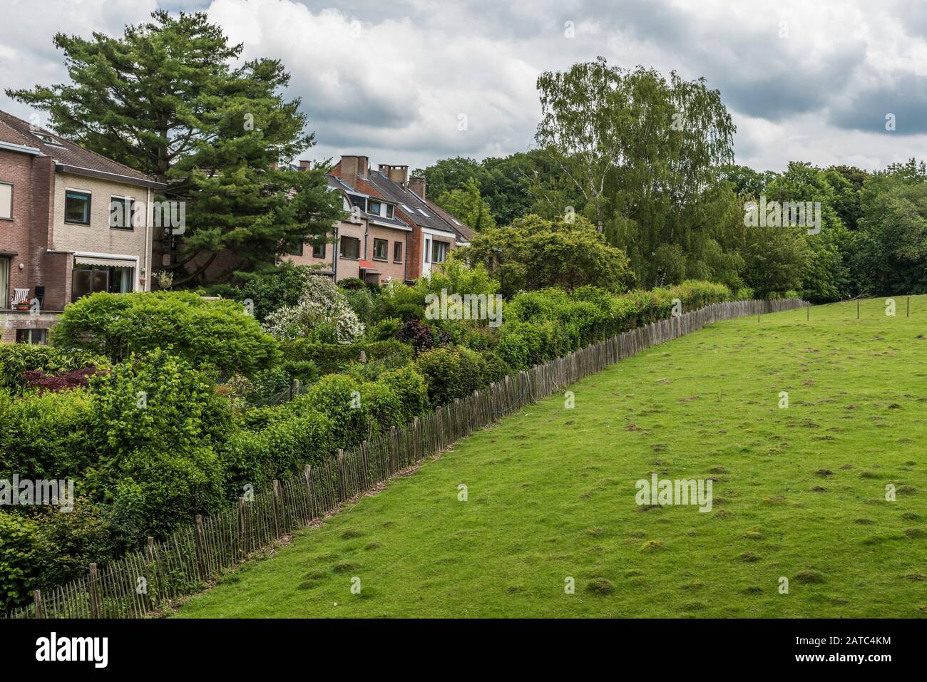 Uccle, Brussels / Belgium - 06 14 2019: View over the green meadows  and trees of the Vronerode with a few residential houses - Fond'Roy city park Stock Photo