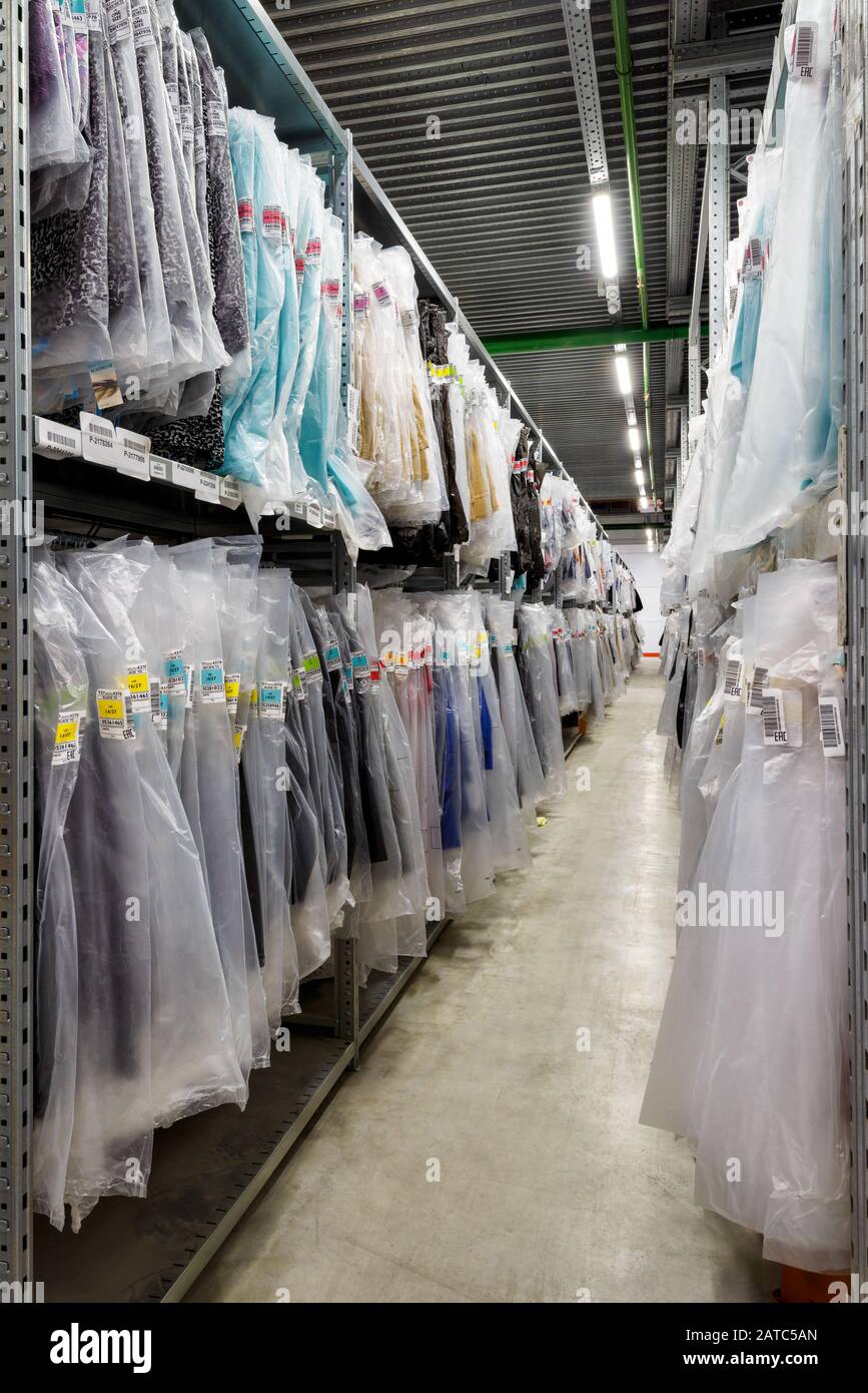 Moscow - March 18, 2016: Clothes are hanging in the large warehouse. Moscow is a modern city with well-developed logistics infrastructure. Stock Photo