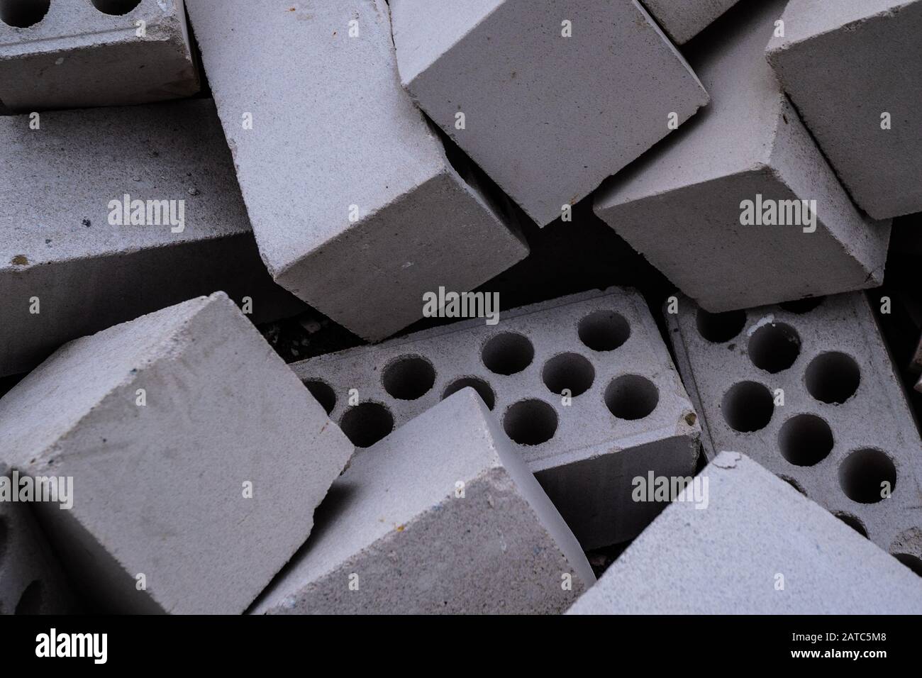 Stack of white hollow facing bricks with holes foreground closeup, white bricks stack Stock Photo