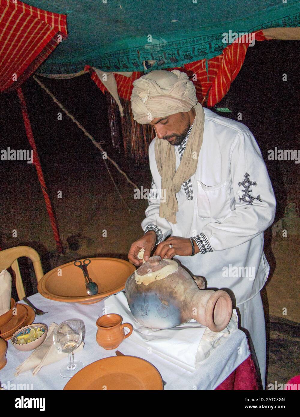 Chef preparing food in the camp restaurant from a traditional clay pot