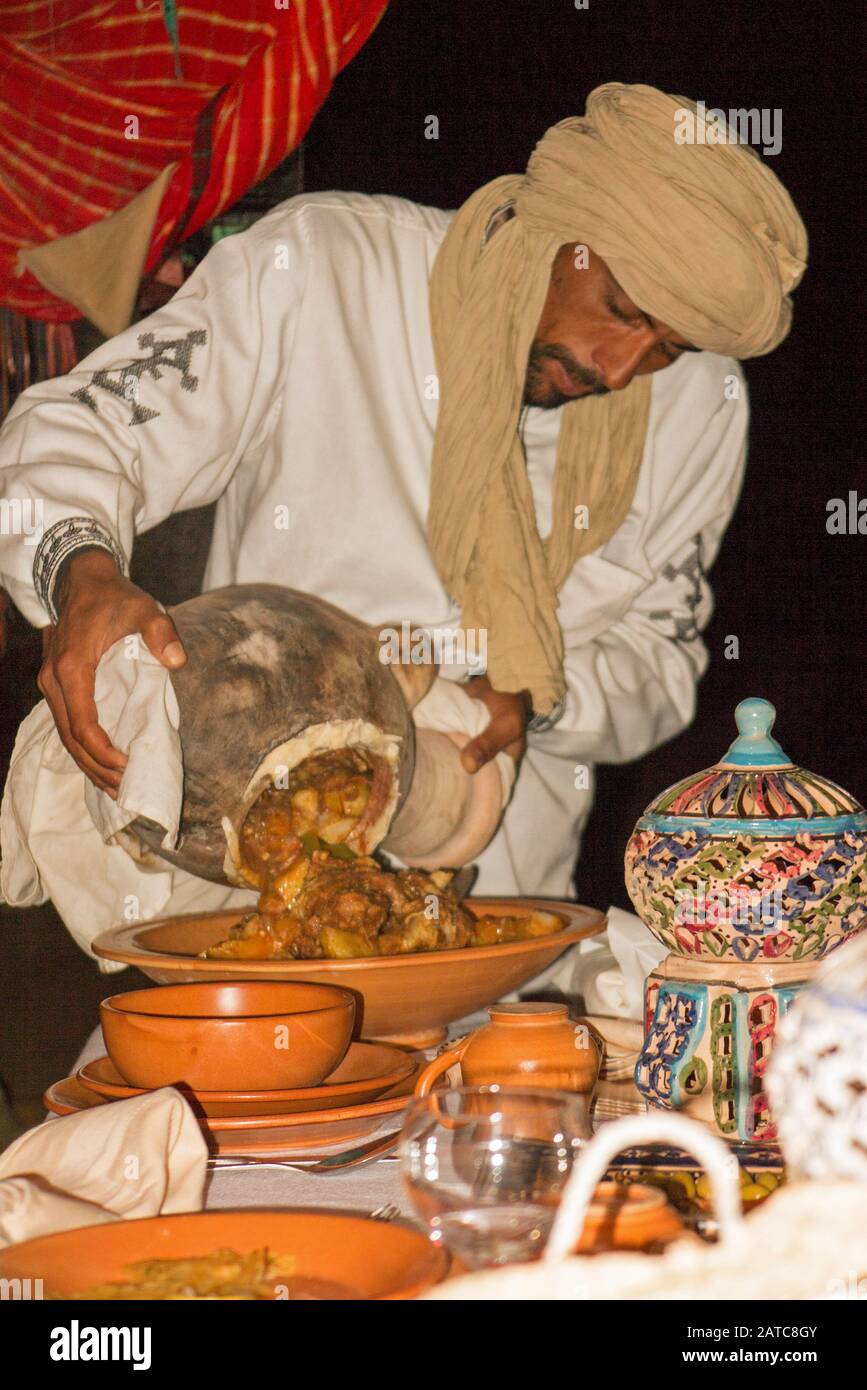 Chef serving food in the camp restaurant from a traditional clay pot. Stewed in charcoal. Stock Photo