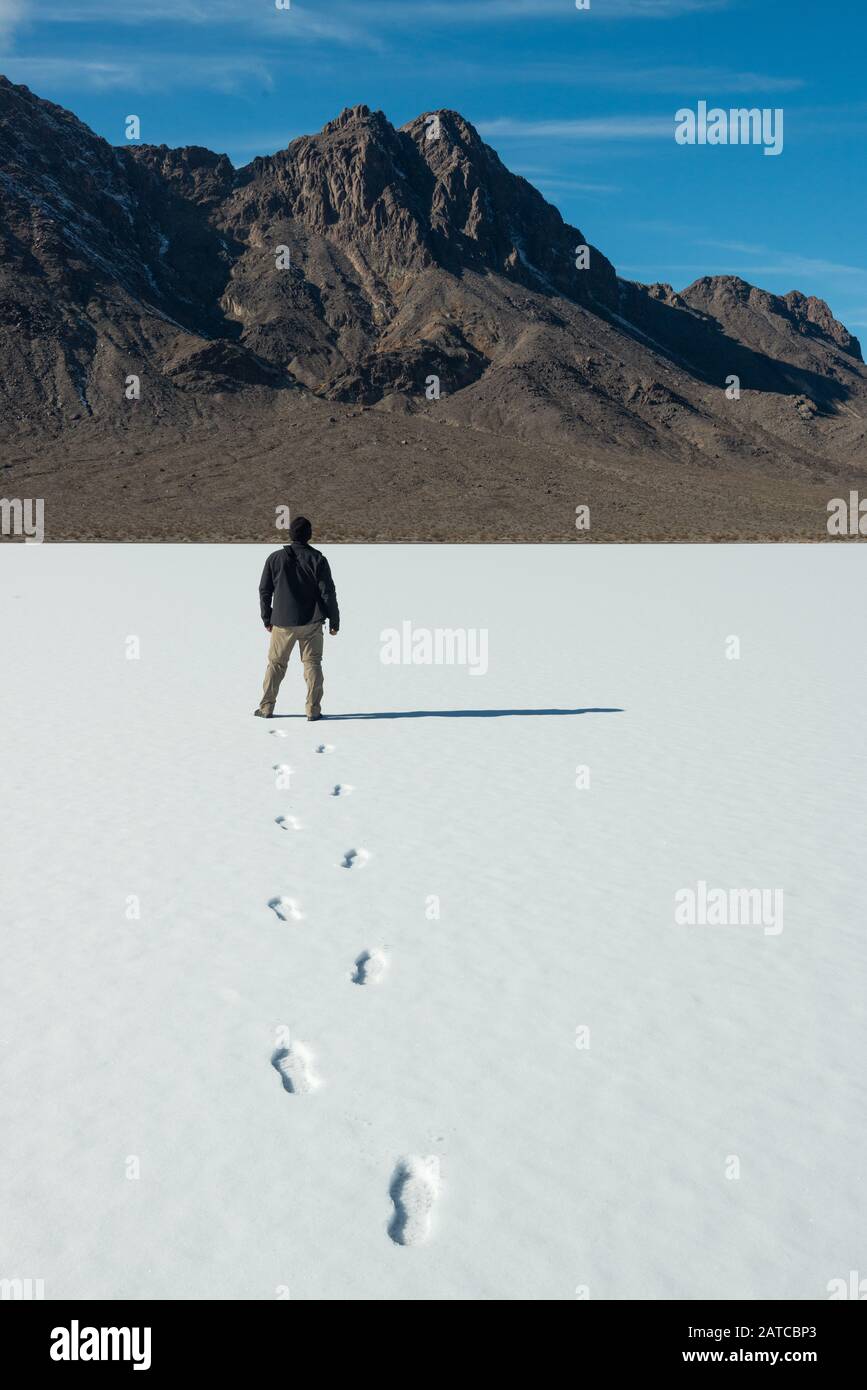 Man walking in the snow on the Racetrack Playa, Death Valley National Park, California, USA Stock Photo