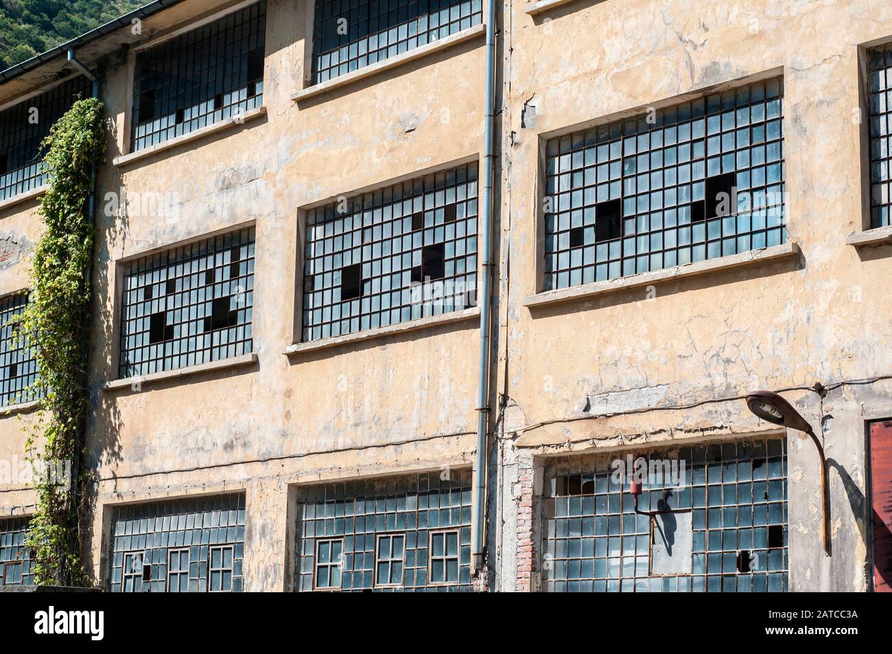 Old obsolete industrial building facade with broken windows Stock Photo