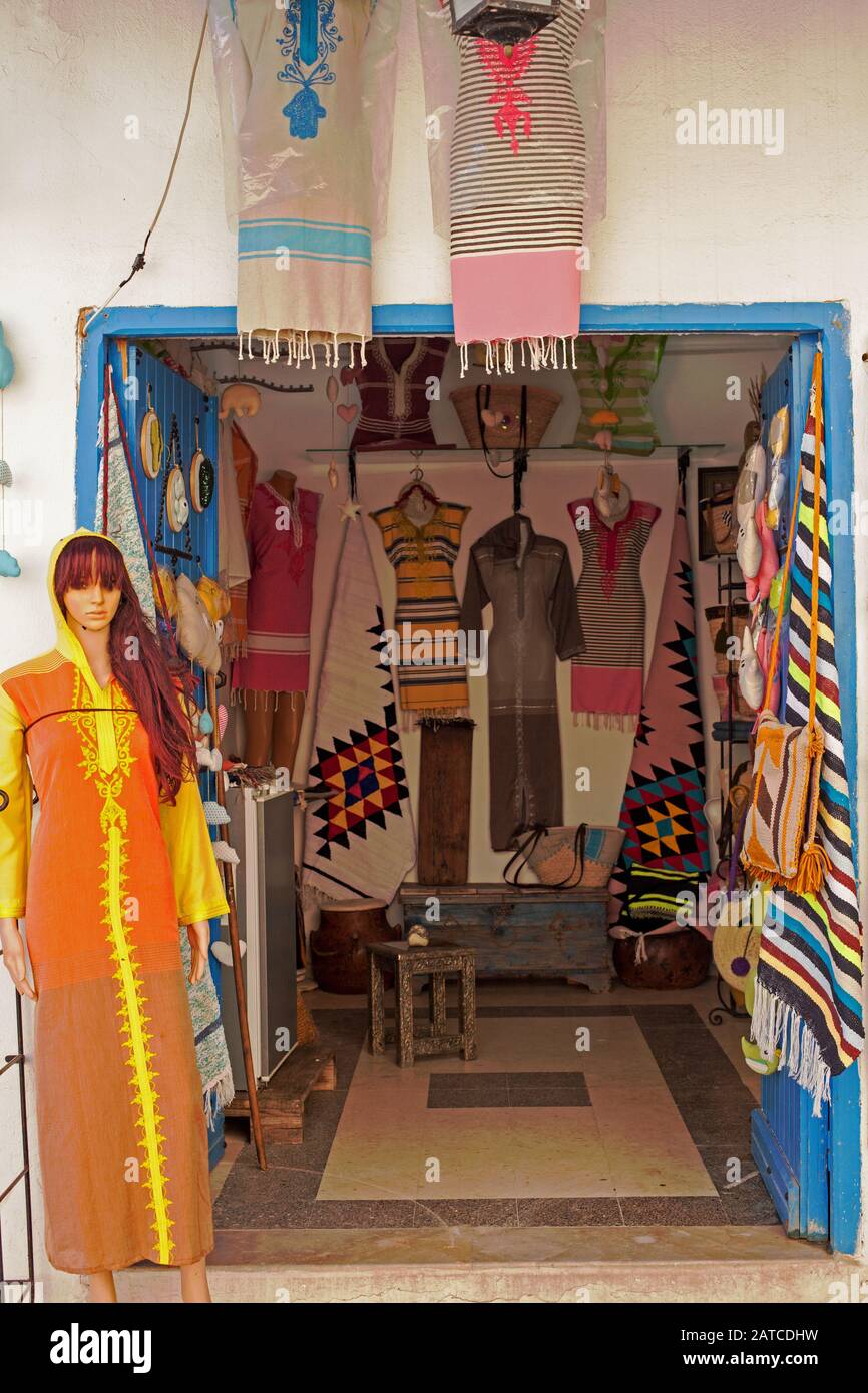 Women's dresses are hung on the walls of a small market stall Stock Photo