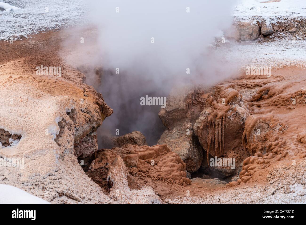 Steam and red mud are vented out of a fumarole. Yellowstone National Park, Wyoming, USA Stock Photo