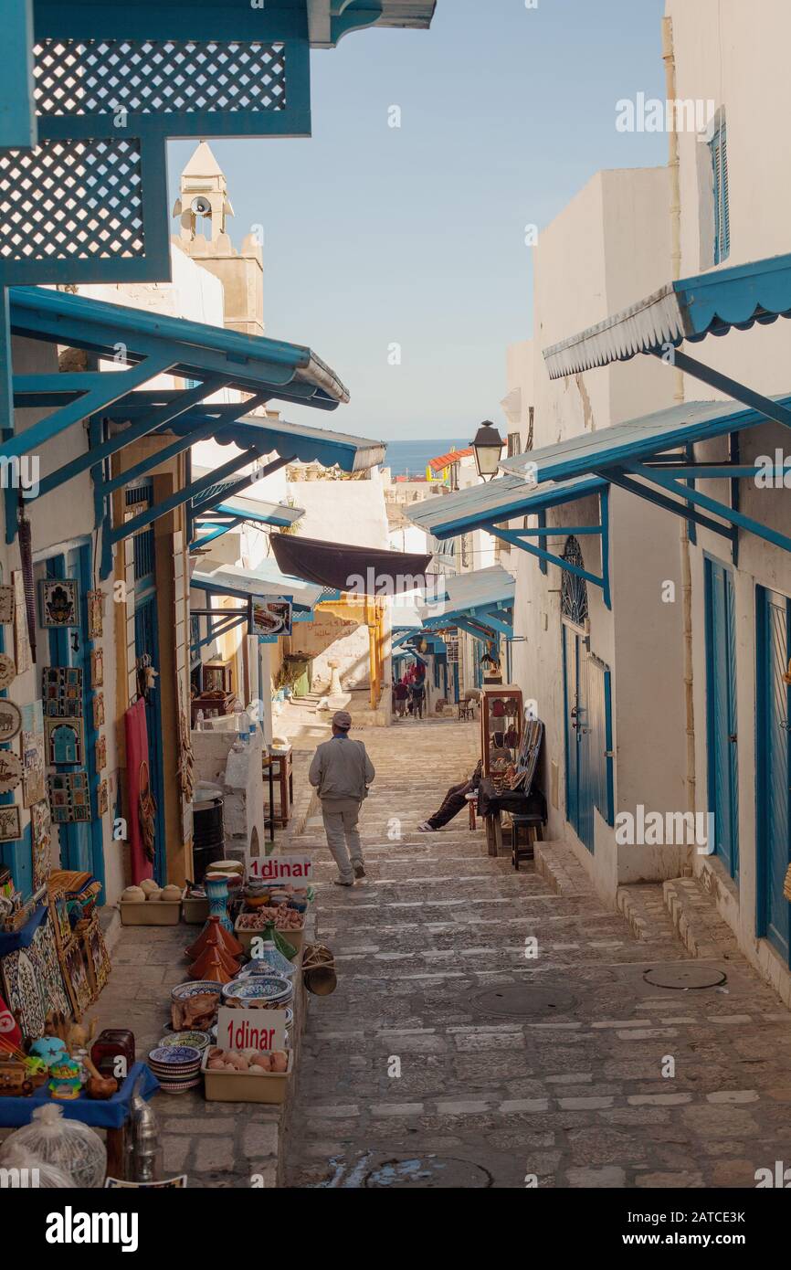 A man walks down towards the sea on Sousse's Medina alley Stock Photo