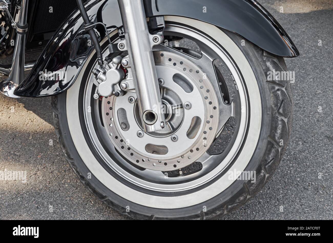 Front wheel of chopper motorcycle. Closeup depicts wheel mount and