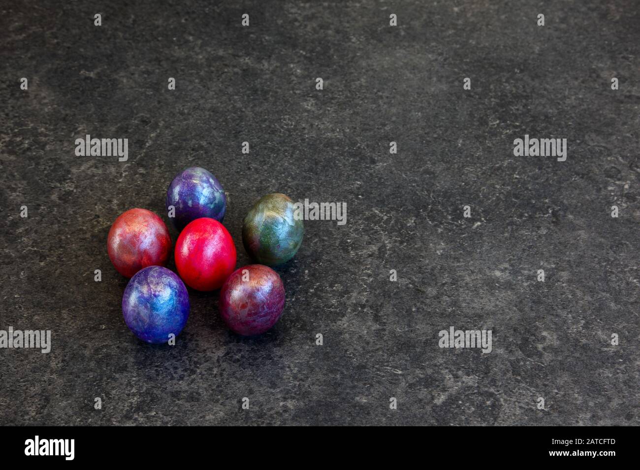 Six coloured marbled eggs on dark background Stock Photo