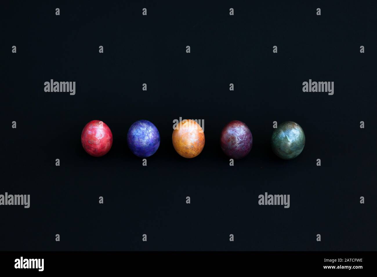 colourful marbled eggs on black background Stock Photo