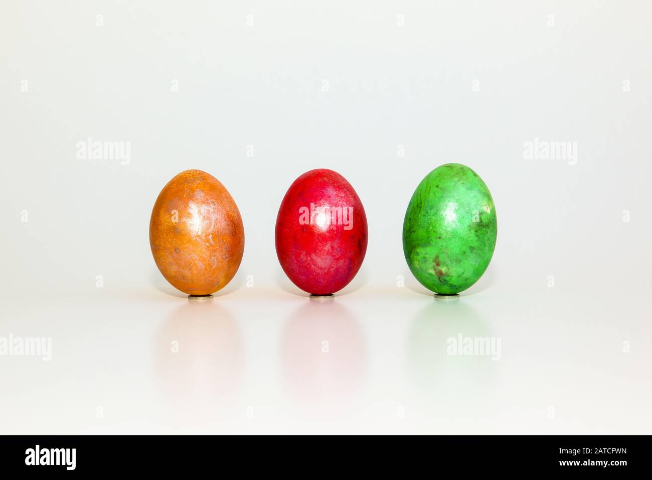 Yellow, red and green egg on white background Stock Photo