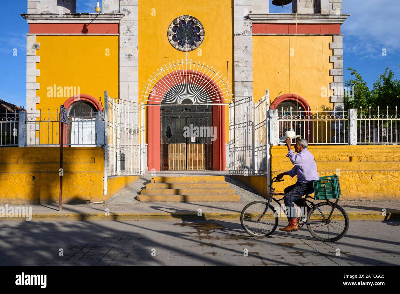 Man riding bicycle in front of the church in San Blas, Riviera Nayarit, Mexico. Stock Photo