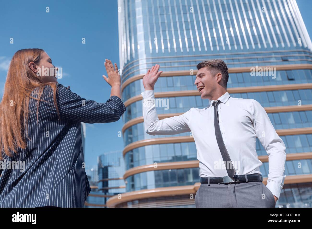 happy young employees giving each other a high five Stock Photo - Alamy