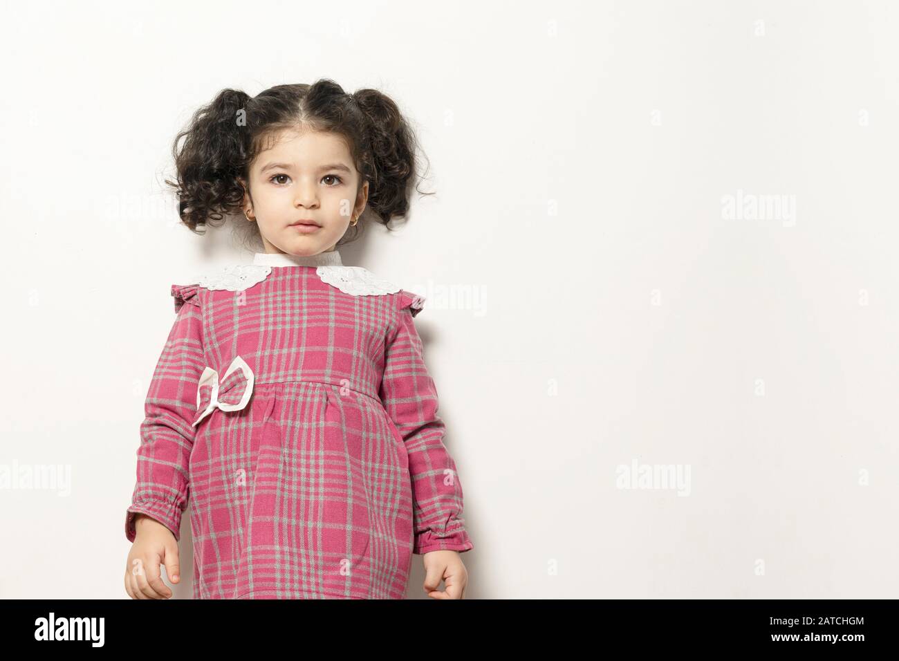 Little Girl With Two Parts Side Pony Hairstyle Looking In Camera