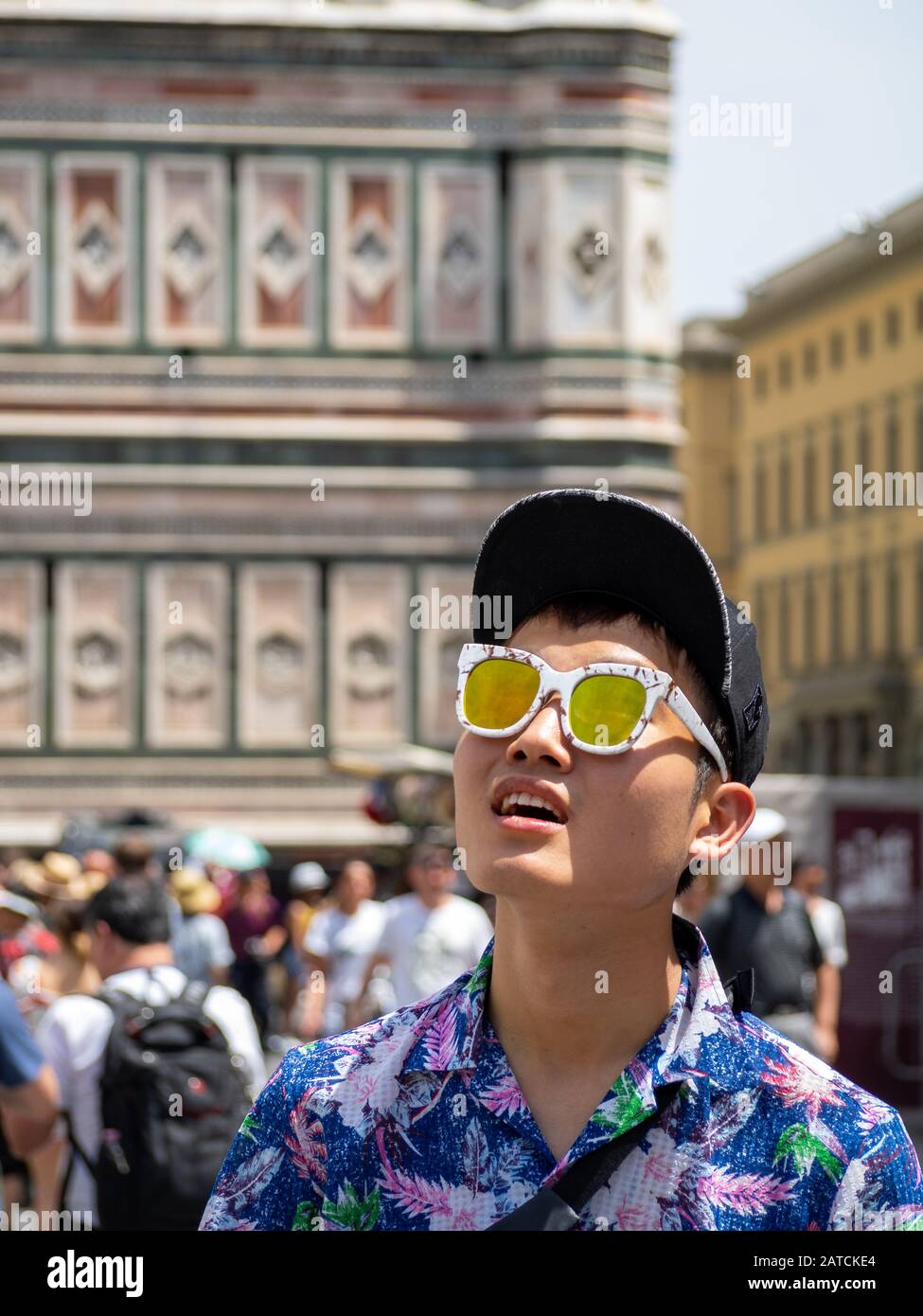 An asian tourists in sunglasses looks up by Duomo di Firenze Stock Photo