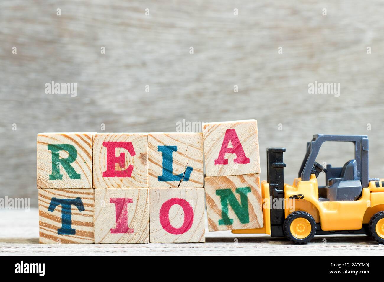 Toy forklift hold letter block a, n to complete word relation on wood background Stock Photo