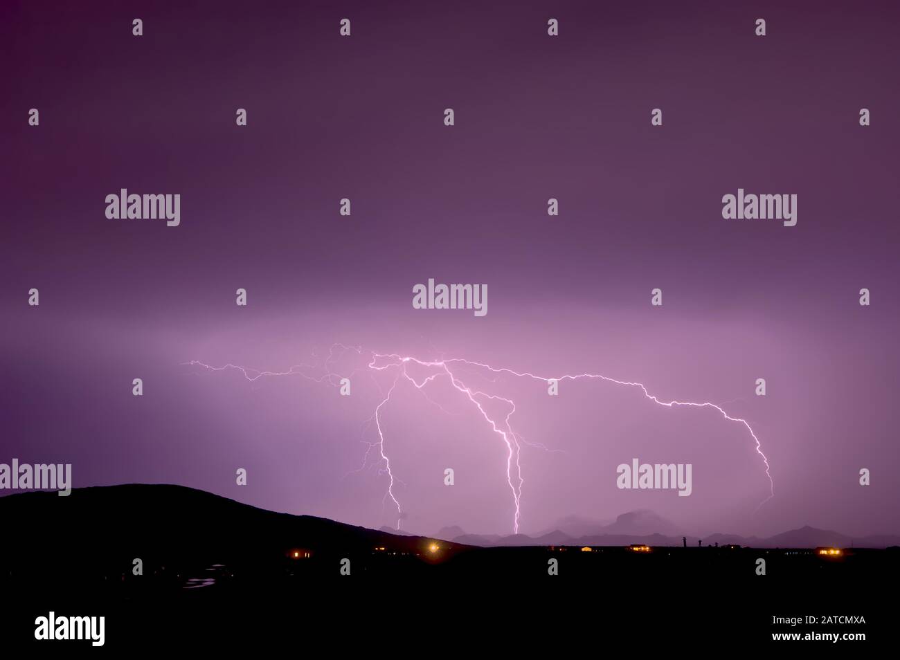 Lightning striking the Gila Bend Mountains in Arizona during a 2011 Monsoon storm. The pink color was created by the lightning passing through dust sa Stock Photo