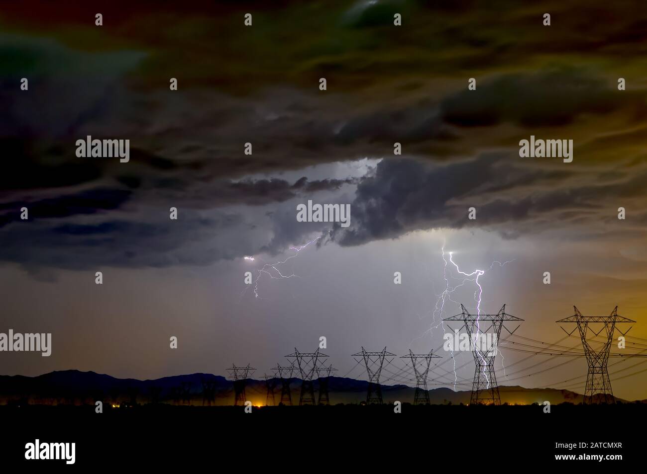 Lightning striking near some high tension powerlines during a late night Arizona Monsoon Storm. Stock Photo