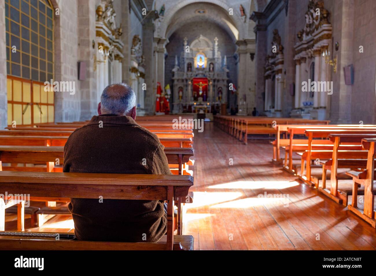 Christian prayer, alone man praying inside church, Cathedral Basilica of St. Charles Borromeo, Catedral Basílica San Carlos Borromeo, Puno, Peru Stock Photo