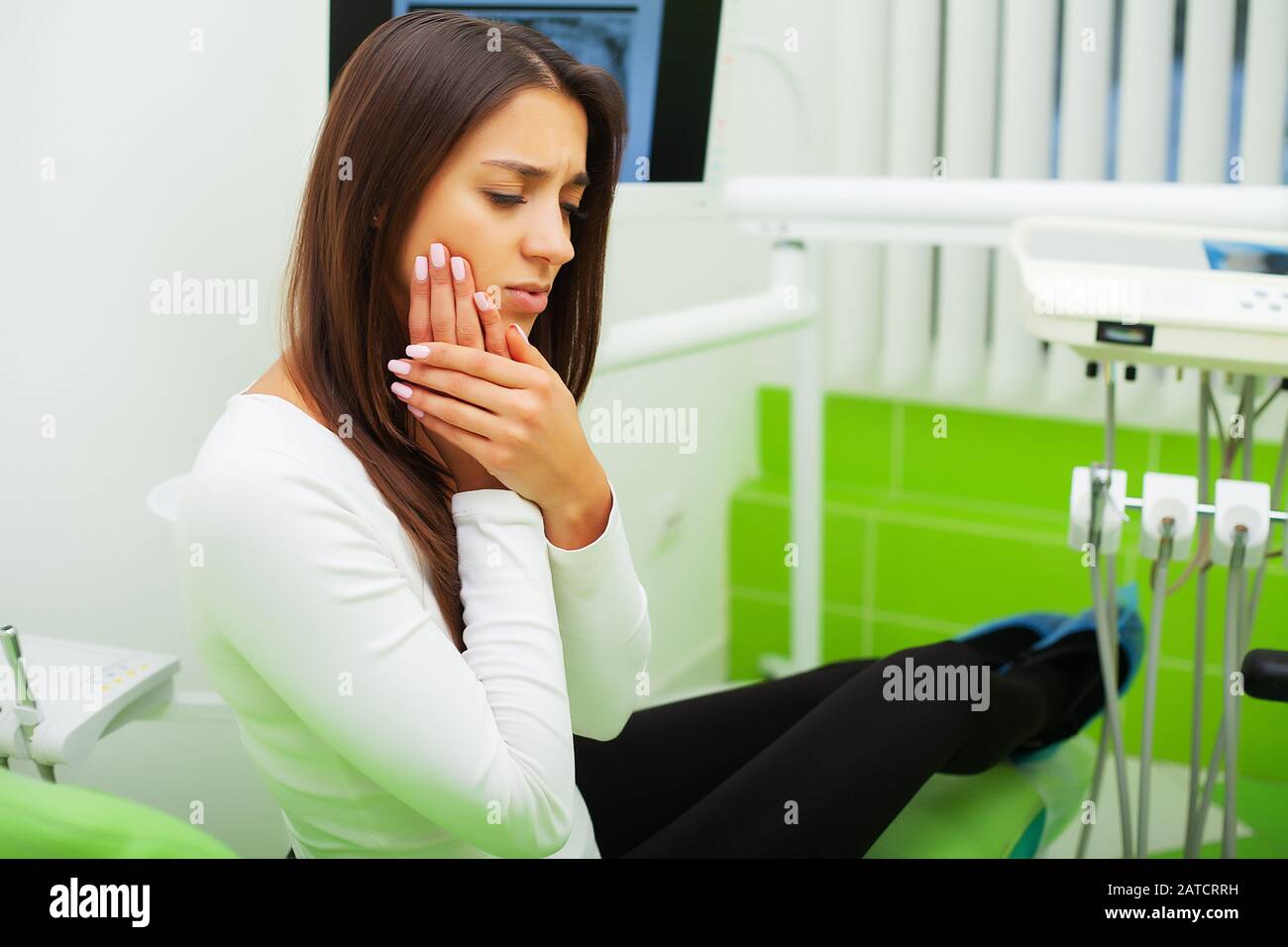 Upset woman at the dentist with constant pulsating tooth pain Stock