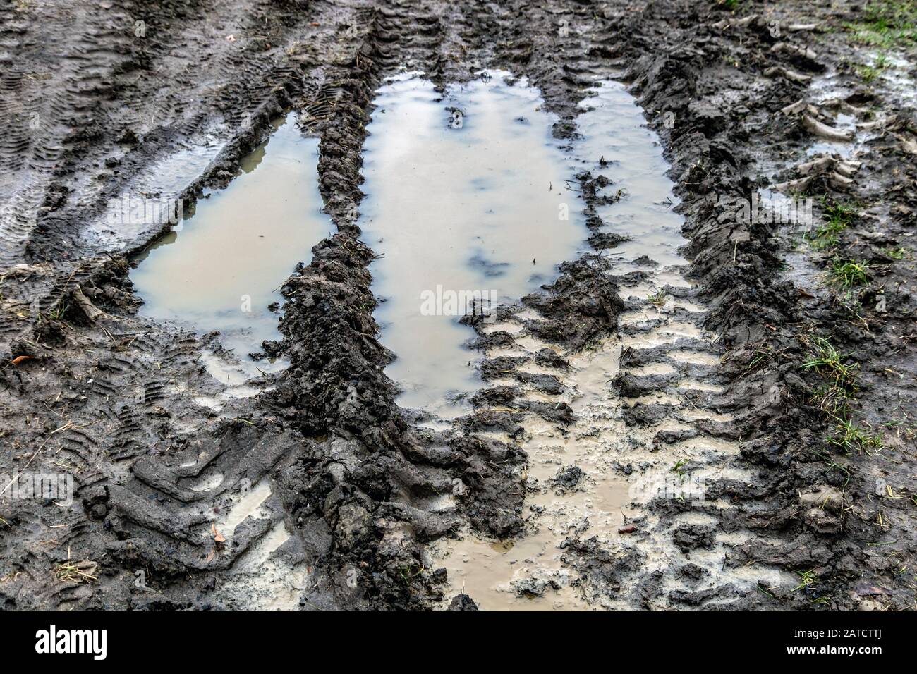 A construction site with traces of cars in the mud. Traces of trucks in the mud. Muddy way with puddles. Stock Photo