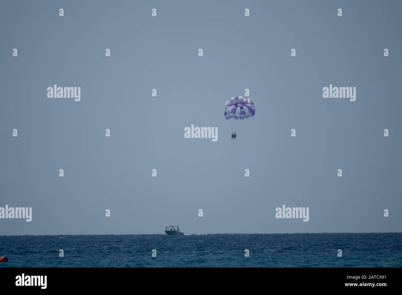 Boat parachuting in the ocean on a grey background Stock Photo Alamy