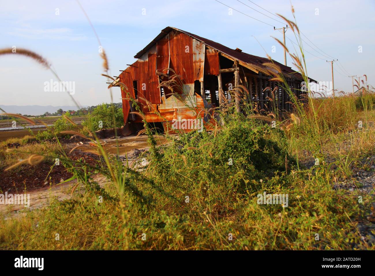 An old rusty tin house used to store harvested salt in the salt farms in Kampot, Cambodia Stock Photo