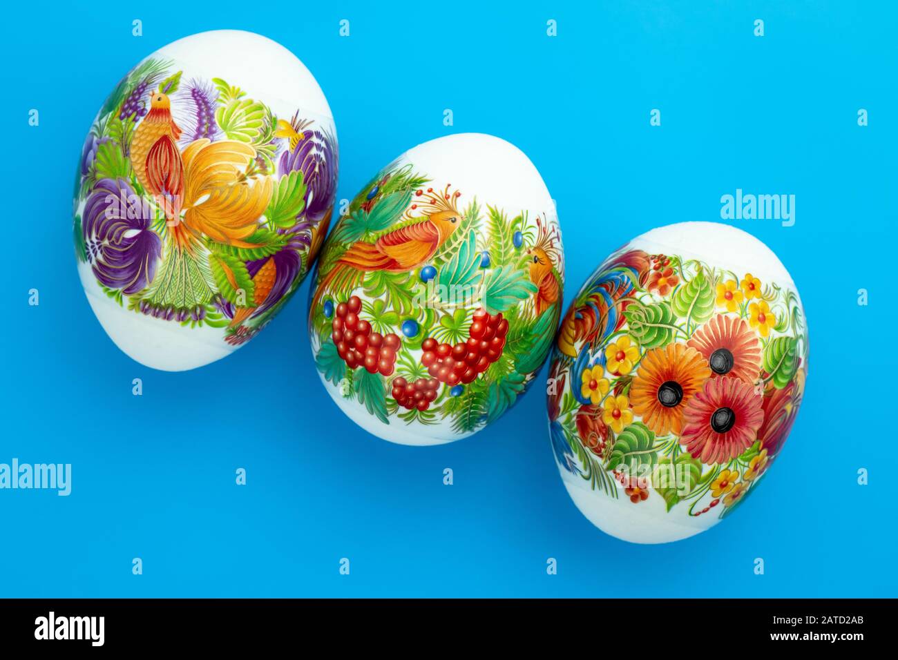 Decorated Paschal chicken eggs on blue background. Easter colored gift card Stock Photo