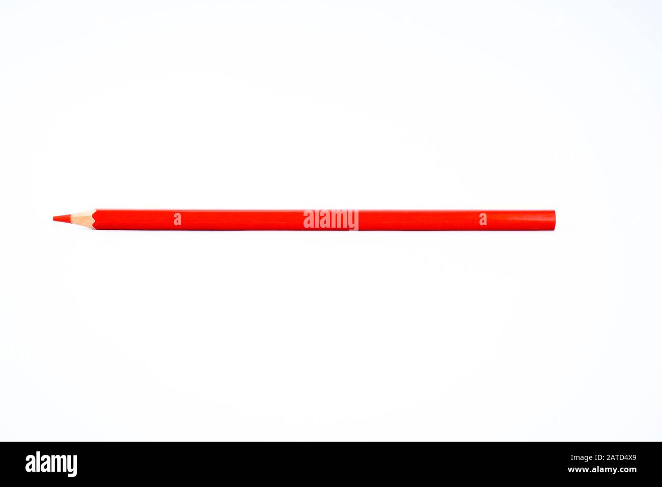 A sharpened red colored pencil crayon is isolated on a white background Stock Photo
