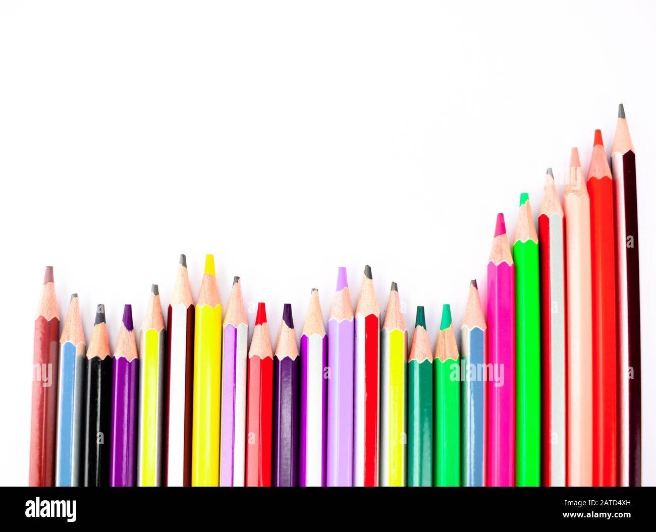 A stack of different colored pencil crayons arranged on a white background Stock Photo