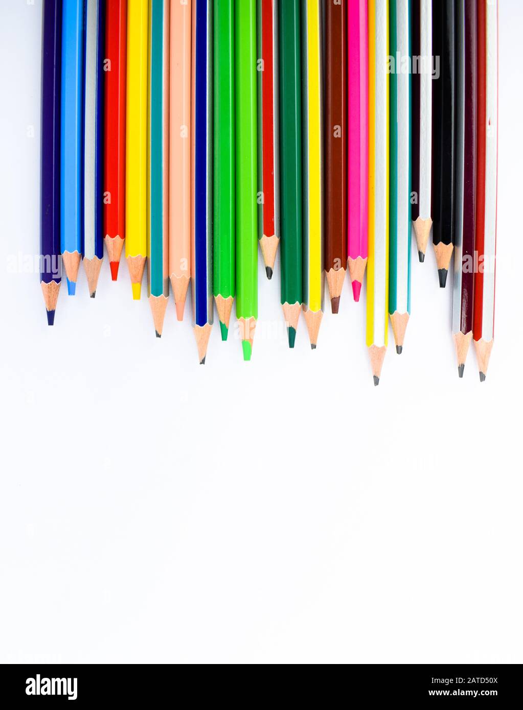 Line of different colored pencil and crayons on a white background