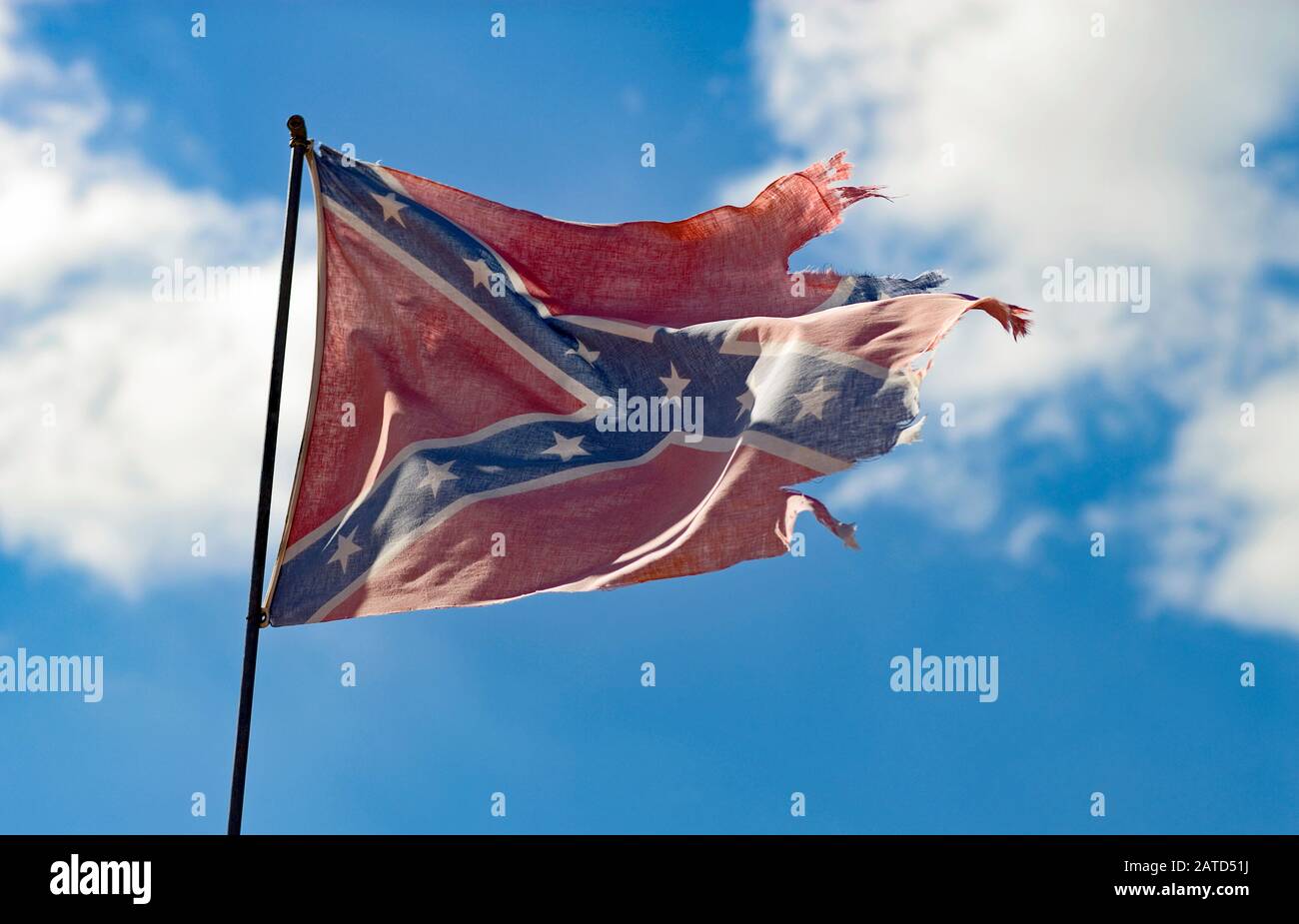 A wind-tattered Confederate flag flies over a trailer park is southwest Alabama. Stock Photo