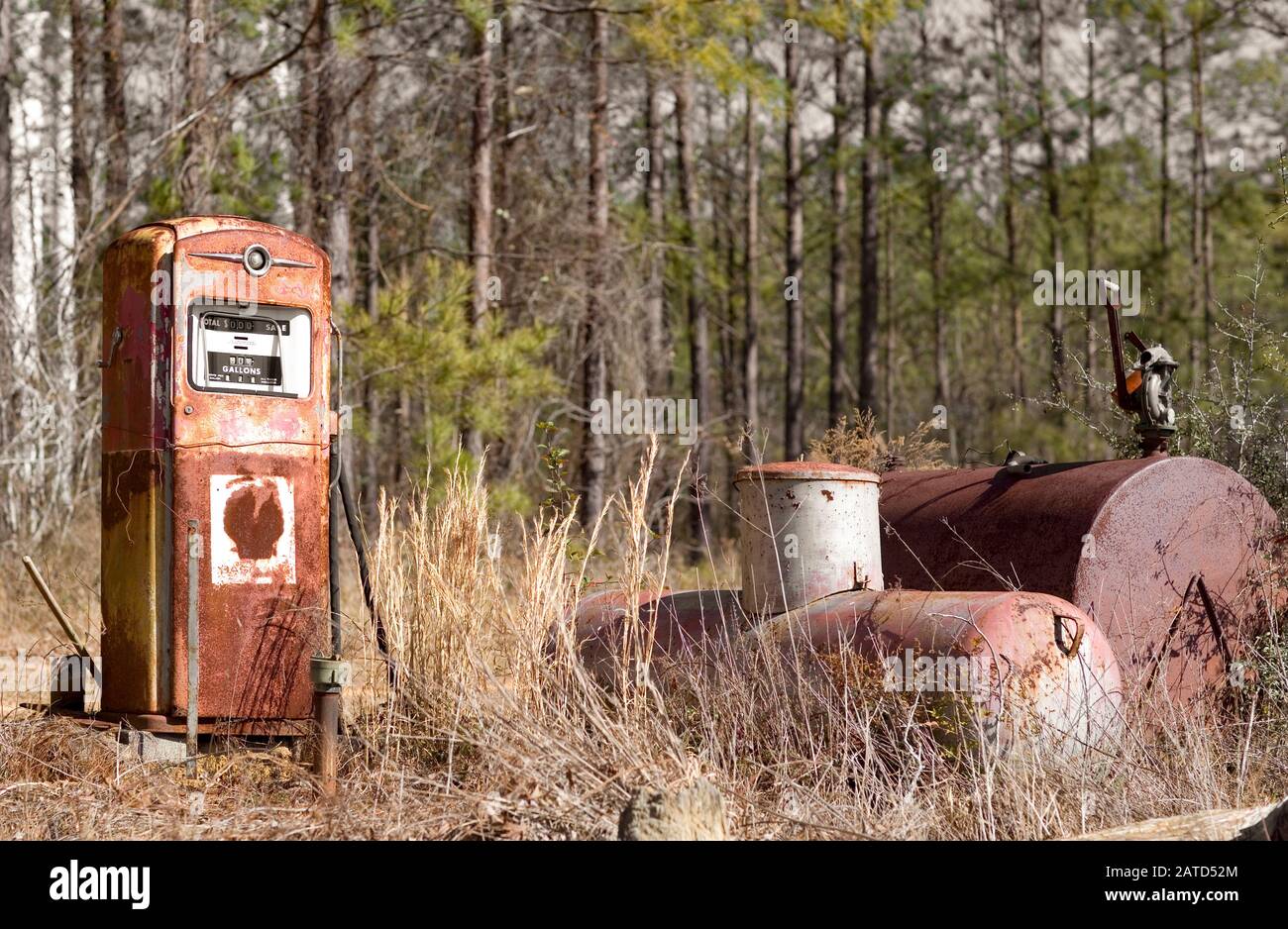An old Shell Oil Company gasoline fuel pump next to a propane, and a diesel fuel tank, in an overgrown lot where a filling station used to be. Stock Photo