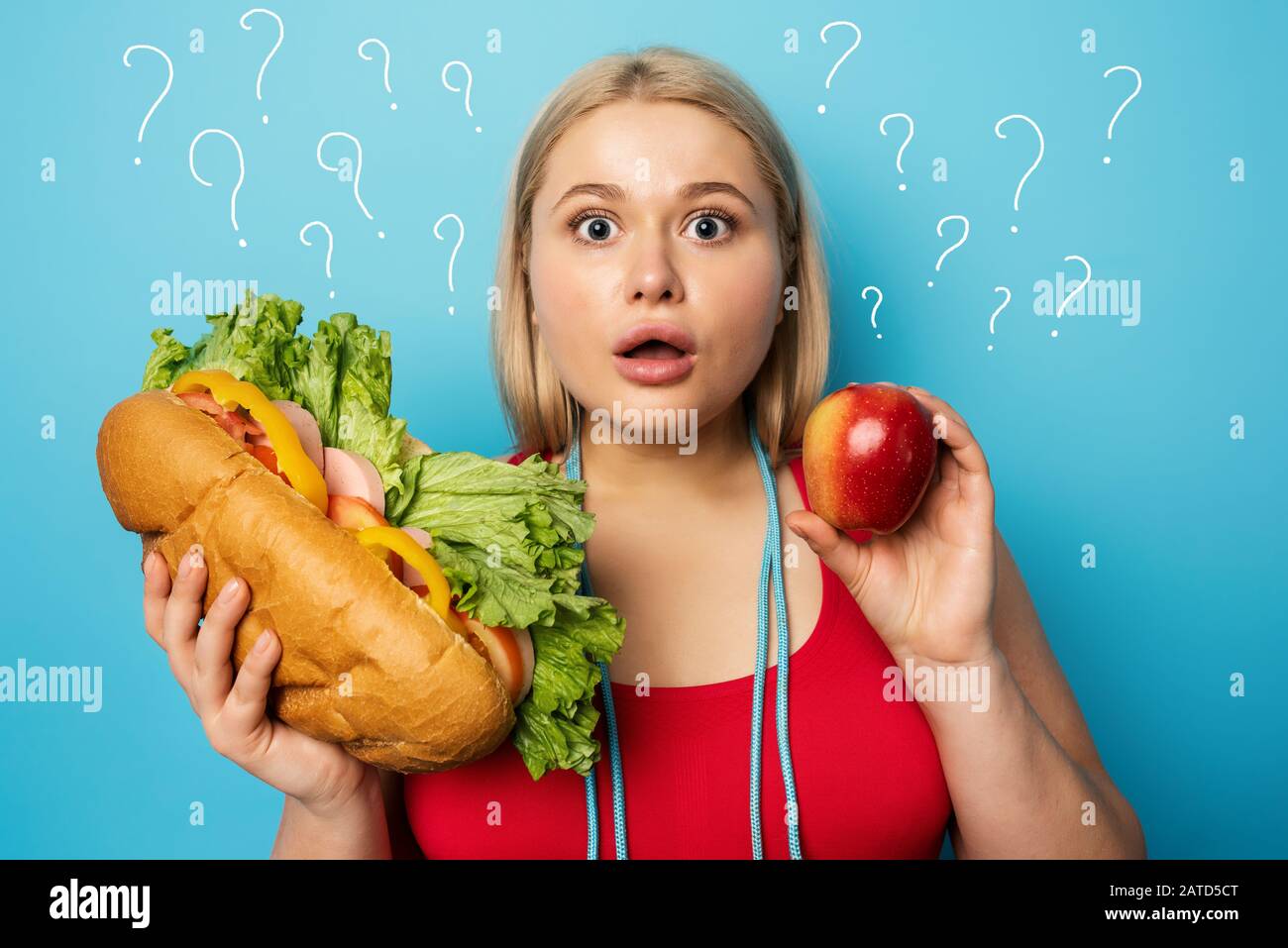 Fat girl does gym and want to eat a sandwich. Concept of indecision and doubt Stock Photo
