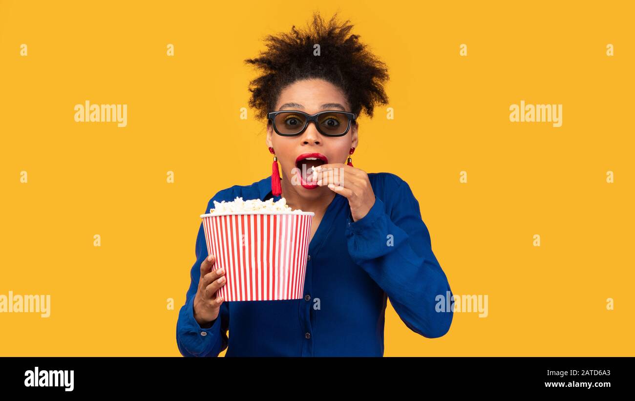 Surprised black girl with popcorn looking at camera Stock Photo