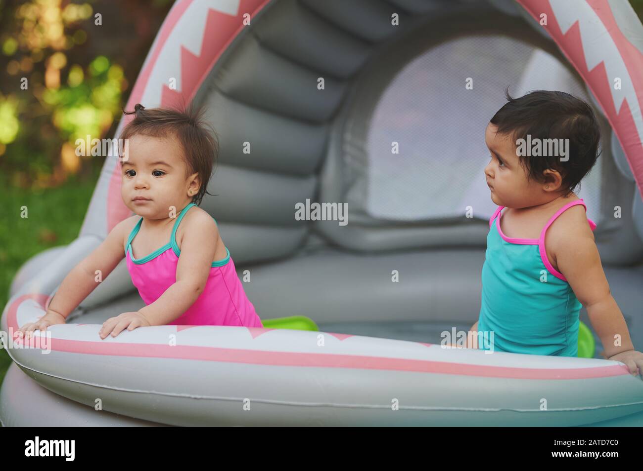 Two kids on rubber swimming pool on house backyard Stock Photo