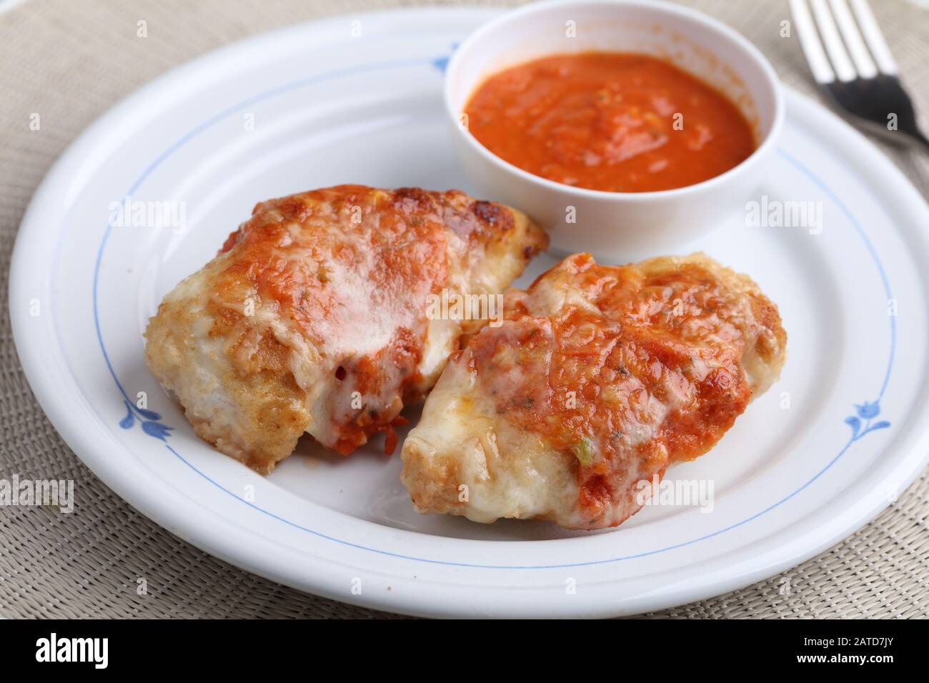 Chicken parmigiana served with tomato sauce Stock Photo