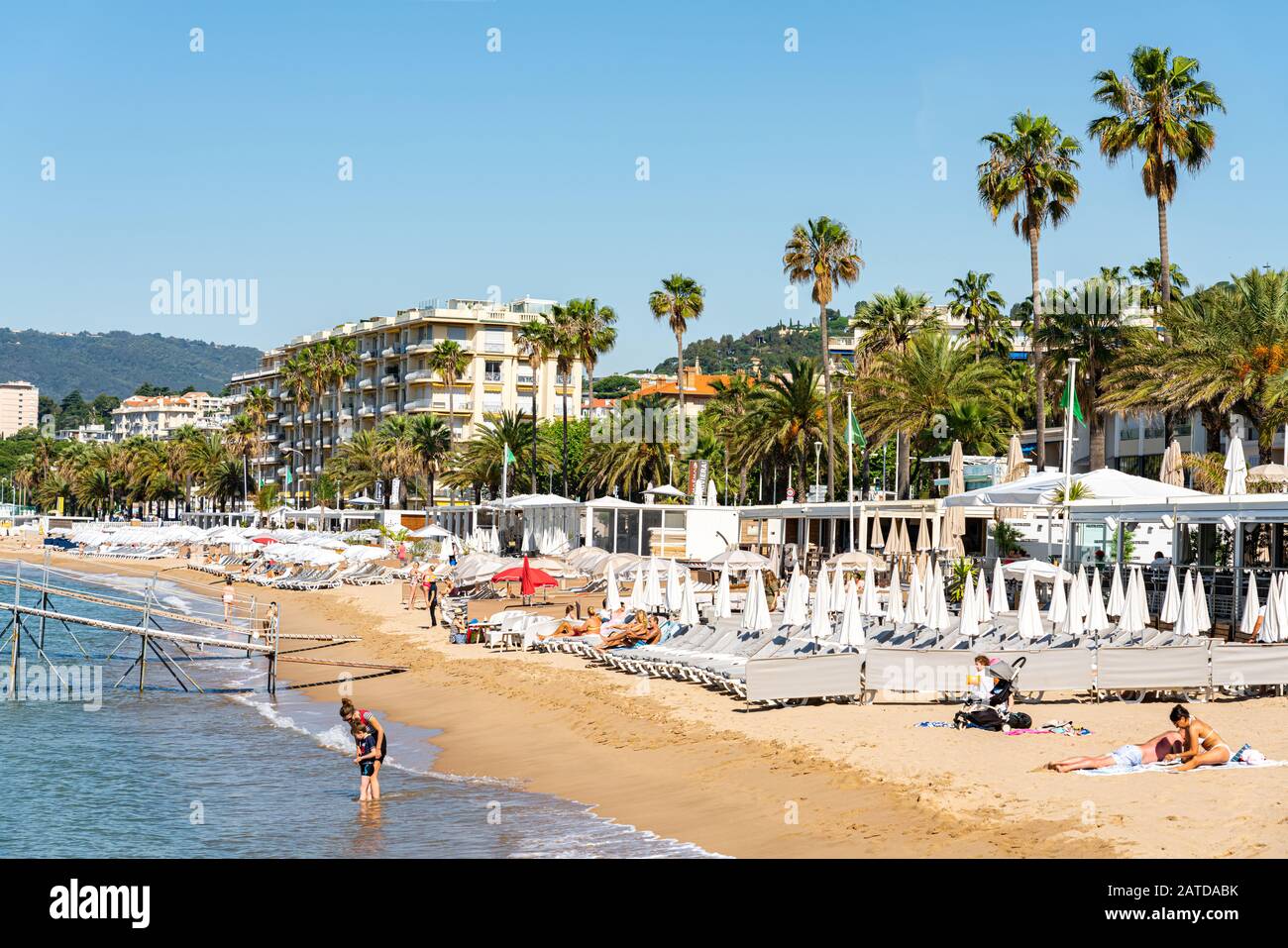 CANNES, FRANCE - JUNE 01, 2019: People Having Fun On Cannes City Beach At The Mediterranean Sea Stock Photo
