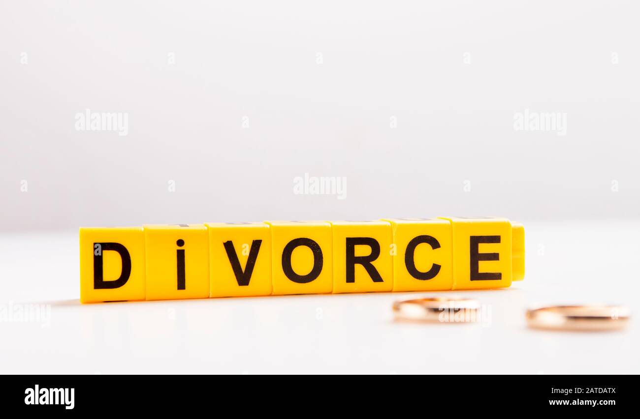 Letters divorce and engagement rings on white table Stock Photo