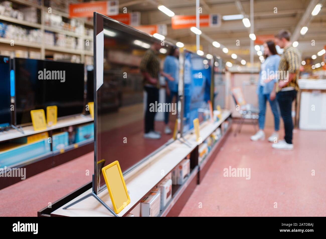Couple at the shelf with TV in electronics store Stock Photo