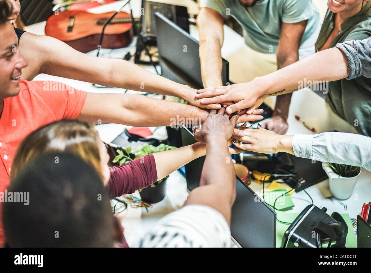 Young team putting hands up for new startup in creative office ...