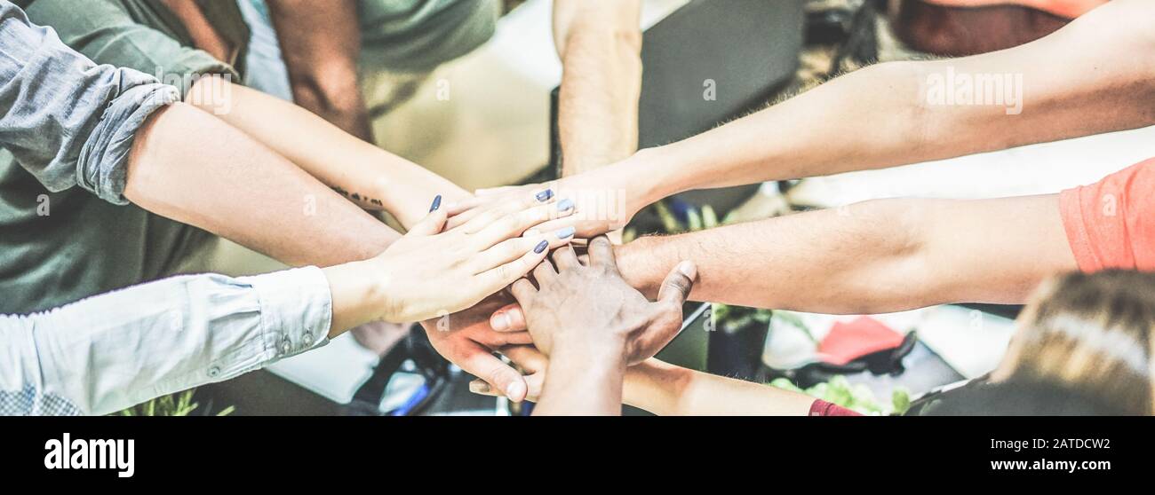 Work team stacking hands together for new startup project - Diverse culture people giving strength motivation to each others - Focus on blue nails wom Stock Photo