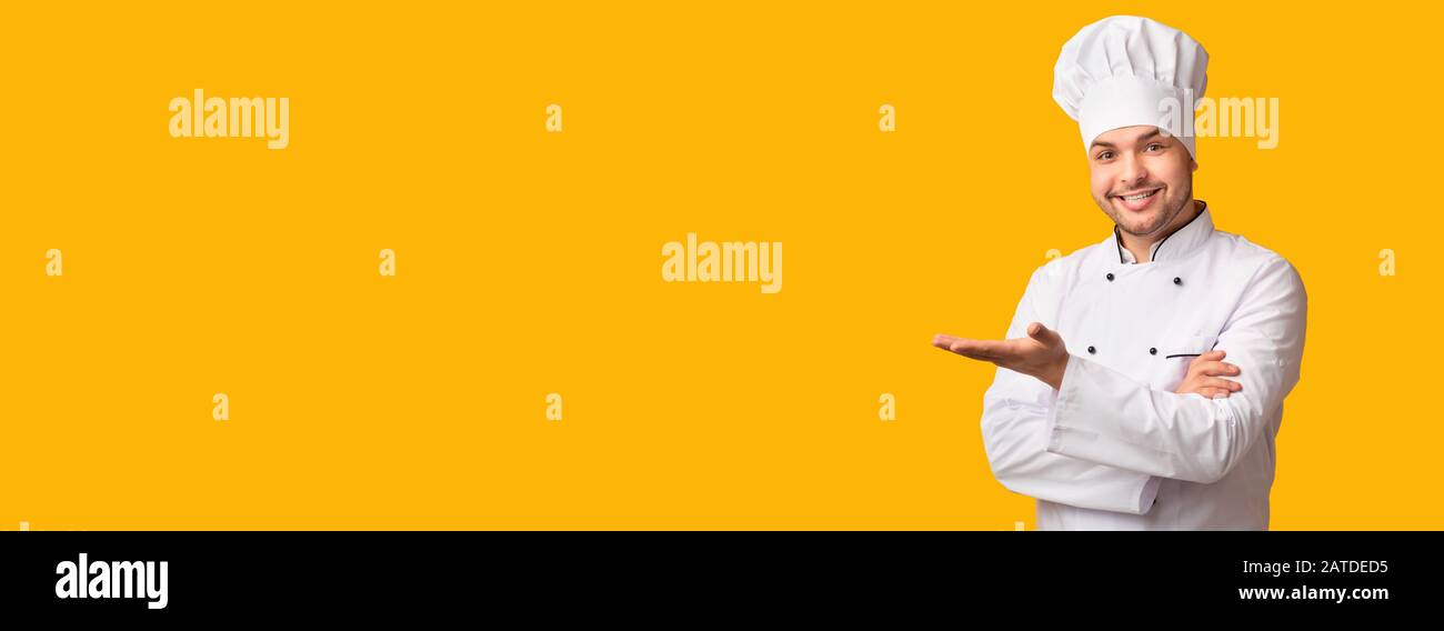 Cook Man Gesturing Showing Something Standing Over Yellow Background, Panorama Stock Photo